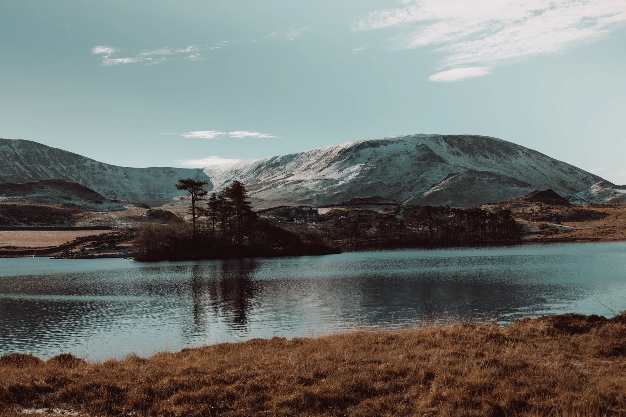 A still mountain lake beneath snow-dusted peaks